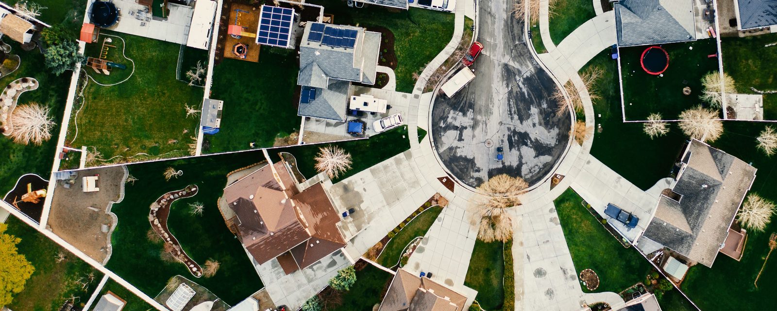 A top-down aerial view of a residential cul-de-sac. Houses sit on pie-shaped lots around the rounded end of the street, with fences dividing the back yards.